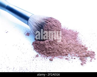 Geringe Schärfentiefe auf Pinsel und kosmetisches loses Pulver auf einem weiß gefärbten Hintergrund. Leicht kühl getönte Stockfoto