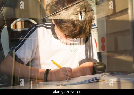 Enthusiastisches Kind, das für die Schule studiert. Hausaufgaben Stockfoto