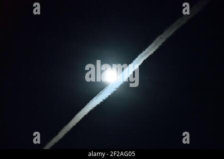 Vapor Trail vorbei am Mond Stockfoto