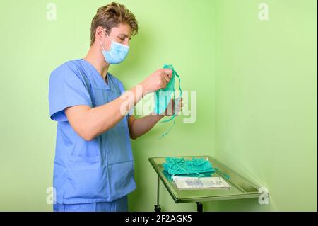 Covid-19. Krankenschwester legt Schutzlappen an. Persönliche Schutzausrüstung im Kampf gegen Coronavirus-Krankheit . Hochwertige Fotos Stockfoto