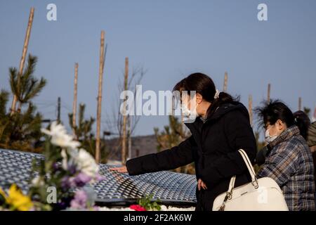 Ishinomaki, Japan. März 2021, 11th. Auf der Namensliste im eröffneten Gedenkpark in Ishinomaki suchen die Menschen nach Namen ihrer Angehörigen. Familien und Freunde kommen und suchen nach Namen und bieten Blumen und Kostenträger zum Gedenken an die Lieben im neuen Gedenkpark, der heute in Ishinomaki eröffnet wurde. Japan ist 10 Jahre her, seit ein massives Erdbeben, Tsunami und eine Atomkrise den Nordosten Japans hart getroffen haben. Kredit: SOPA Images Limited/Alamy Live Nachrichten Stockfoto