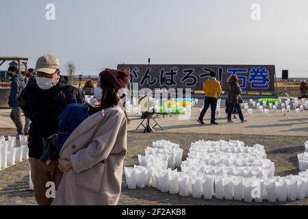 Ishinomaki, Japan. März 2021, 11th. Familien und Freunde kommen und suchen nach Namen und bieten Blumen und Kostenträger zum Gedenken an die Lieben im neuen Gedenkpark, der heute in Ishinomaki eröffnet wurde. Japan ist 10 Jahre her, seit ein massives Erdbeben, Tsunami und eine Atomkrise den Nordosten Japans hart getroffen haben. Kredit: SOPA Images Limited/Alamy Live Nachrichten Stockfoto