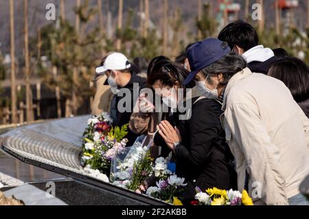 Ishinomaki, Japan. März 2021, 11th. Familien und Freunde kommen und suchen nach Namen und bieten Blumen und Kostenträger zum Gedenken an die Lieben im neuen Gedenkpark, der heute in Ishinomaki eröffnet wurde. Japan ist 10 Jahre her, seit ein massives Erdbeben, Tsunami und eine Atomkrise den Nordosten Japans hart getroffen haben. Kredit: SOPA Images Limited/Alamy Live Nachrichten Stockfoto