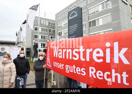 Nürnberg, Deutschland. März 2021, 11th. Mitarbeiter des Lkw-Herstellers MAN in Nürnberg protestieren vor dem Unternehmen für mehr Lohn. Im Lohnstreit in der Metall- und Elektroindustrie forderte die IG Metall Warnstreiks in nicht weniger als 59 Unternehmen. Der regionale Schwerpunkt liegt in Nürnberg, wo Metallarbeiter in 28 Unternehmen ihre Arbeit zwei Stunden früher zur gleichen Zeit um 12 Uhr beenden sollen. Quelle: Daniel Karmann/dpa/Alamy Live News Stockfoto