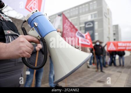 Nürnberg, Deutschland. März 2021, 11th. Mitarbeiter des Lkw-Herstellers MAN in Nürnberg protestieren vor dem Unternehmen für mehr Lohn. Im Lohnstreit in der Metall- und Elektroindustrie forderte die IG Metall Warnstreiks in nicht weniger als 59 Unternehmen. Der regionale Schwerpunkt liegt in Nürnberg, wo Metallarbeiter in 28 Unternehmen ihre Arbeit zwei Stunden früher zur gleichen Zeit um 12 Uhr beenden sollen. Quelle: Daniel Karmann/dpa/Alamy Live News Stockfoto