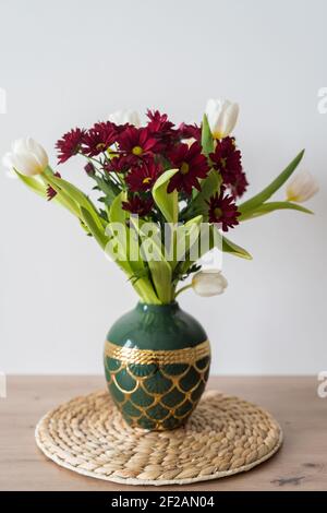 Bouquet von Tulpen und Chrysanthemen in einer Vase auf weißem Hintergrund. Stockfoto