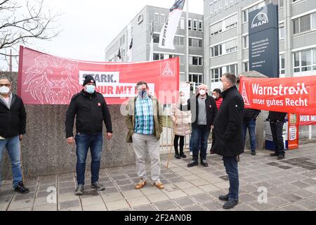 Nürnberg, Deutschland. März 2021, 11th. Mitarbeiter des Lkw-Herstellers MAN in Nürnberg protestieren vor dem Unternehmen für mehr Lohn. Im Lohnstreit in der Metall- und Elektroindustrie forderte die IG Metall Warnstreiks in nicht weniger als 59 Unternehmen. Der regionale Schwerpunkt liegt in Nürnberg, wo Metallarbeiter in 28 Unternehmen ihre Arbeit zwei Stunden früher zur gleichen Zeit um 12 Uhr beenden sollen. Quelle: Daniel Karmann/dpa/Alamy Live News Stockfoto