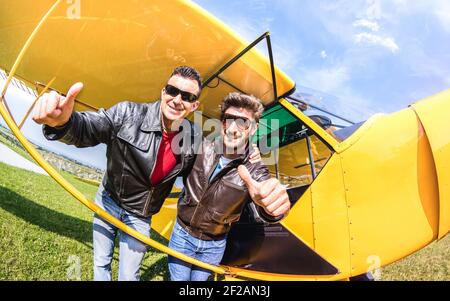 Glückliche beste Freunde, die Selfie im aeroclub mit ultra Licht machen Flugzeug - Luxus Freundschaft Konzept über junge Menschen mit Daumen Hoch haben Stockfoto