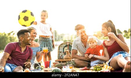 Glückliche multirassische Familien mit Spaß zusammen mit Kindern bei pic nic Grillparty - multikulturelle Freude und Liebe Konzept mit Gemischtes Volk Stockfoto