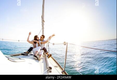 Junges Paar in der Liebe auf Segelboot mit Champagner an Sunset - Happy People Lifestyle auf exklusivem Luxuskonzept - Weicher Fokus der Hintergrundbeleuchtung Stockfoto