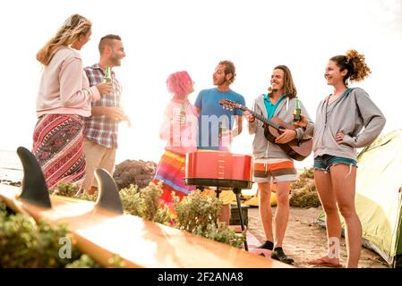 Hipster Freunde Spaß am Strand Camping Party - Wanderlust Reisekonzept mit jungen Leuten Reisende toasten und trinken in Flaschen Bier zusammen Stockfoto