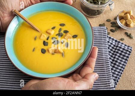 Nahaufnahme Kürbiscreme in der Schüssel. Mit Croutons und Kürbiskernen. Stockfoto