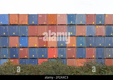 Stapel von Frachtcontainer im Hafen, bunte Wand von Frachtcontainern in der Werft. Nahtlose Textur Industrie Hintergrund, Dublin Port, Meer Stockfoto