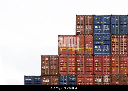 Stapel von Frachtcontainer im Hafen, bunte Wand von Frachtcontainern in der Werft. Nahtlose Textur Industrie Hintergrund, Dublin Port, Meer Stockfoto