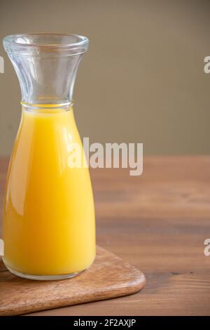Draufsicht auf Flasche Orangensaft auf Holztisch und Tisch, vertikal mit Kopierraum Stockfoto