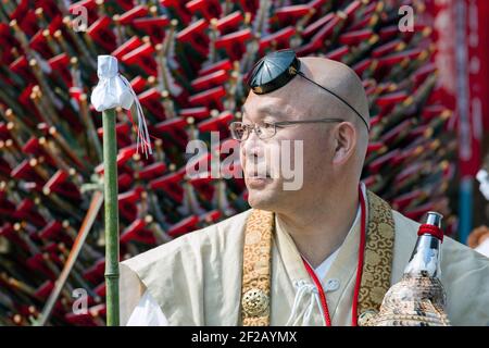 Shugenja Buddhistischer Pilger steht vor Gebetsstöcken beim Hiwatari Matsuri - Fire Walking Festival, Mount Takao, Hachioji, Japan Stockfoto