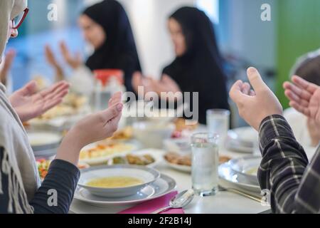 Muslimische Familie macht iftar dua Fasten während Ramadan zu brechen. Stockfoto