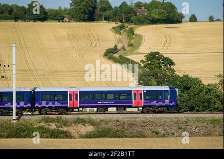 Personenzug der Klasse 377 in der First Capital Connect Lackierung, die durch die englische Landschaft rast. Stockfoto