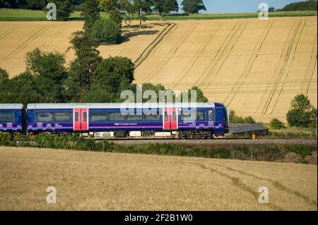 Personenzug der Klasse 377 in der First Capital Connect Lackierung, die durch die englische Landschaft rast. Stockfoto