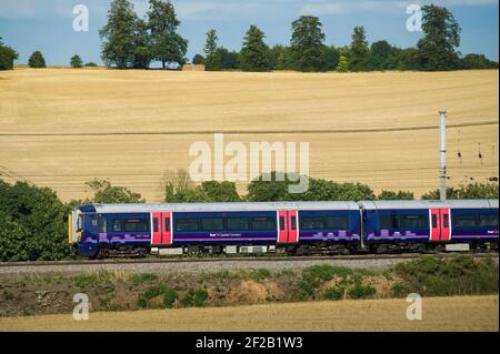 Personenzug der Klasse 377 in der First Capital Connect Lackierung, die durch die englische Landschaft rast. Stockfoto