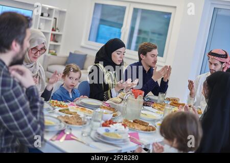 Muslimische Familie macht iftar dua Fasten während Ramadan zu brechen. Stockfoto