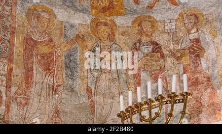 Romanische Wandmalerei der Jungfrau Maria, des Hl. Johannes, des Hl. Paulus und des Hl. Petrus mit einem Schlüssel, Övraby Kirche, Schweden, 6. November 2009 Stockfoto