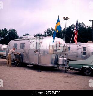 1970 s Camping. Abgebildet ist ein US-amerikanischer Airstream Wohnwagen in Aluminium und im typischen 30er Jahre Design zu optimieren. Die Karawane wurde von Hawley Bowlus, die mit dem Flugzeug " Geist von Saint Louis inspirered wurde entwickelt. Rund um die Welt, Inhaber von Airstream Wohnwagen erfüllen und dieses Bild wurde in Schweden am 21. September 1971 berücksichtigt. Stockfoto