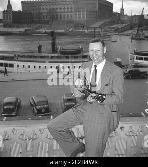 George Formby. Britische Sängerin, Schauspieler als Ukulele-Mann bekannt. 1904-1961. Er war der am höchsten bezahlte britische Schauspieler 1940. Hier abgebildet, als er Stockholm besuchte Schweden spielen die Banjolele auf dem Balkon seines Hotels mit dem königlichen Schloss im Hintergrund. 1946 Ref. T138-1 Stockfoto