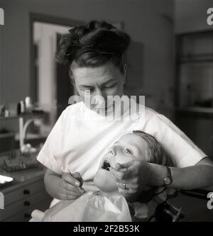 Beim Zahnarzt im 1940s. Ein Junge wird von einem Zahnarzt untersucht und behandelt. Schweden 1948 Ref. AH20-3 Stockfoto