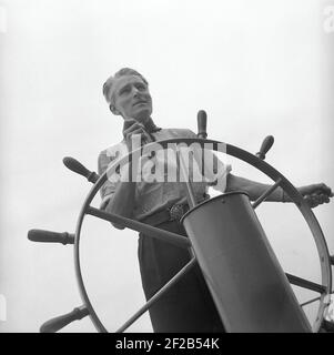 Mann der 1940s. Der jüngste Seekapitän in Schweden 1942 Martin Nyblom, 21 Jahre alt. Hier am Lenkrad abgebildet. Schweden 1942 Ref. A38-5 Stockfoto