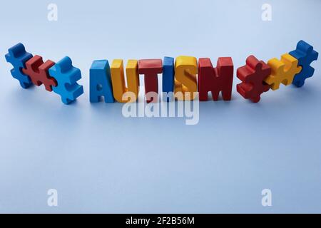 Autismus-Bewusstsein-Konzept mit Puzzle und Wort Autismus auf blauem Hintergrund. Stockfoto