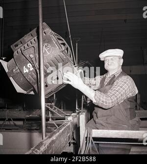 Filmstudio in der 1940s. Ein Mann, der an dem Filmset arbeitet, handhabt die riesige Lampe, mit der die Filmszene während der Aufnahme beleuchtet wird. Der ältere Mann hat eine weiße Mütze auf dem Kopf und macht ein lustiges Gesicht. Aufgenommen im größten Filmstudio in Schweden Filmstaden Råsunda während der Dreharbeiten von Ingmar Bergmans Film Frau ohne Gesicht. Es hatte Premiere september 16 1947. Schweden 1947. ref. AB5-12 Stockfoto