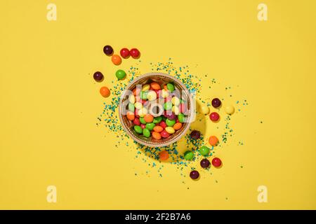 Ostern Backen Hintergrund. Ostern bunten Lebkuchen, Süßigkeiten, verstreute Süßwaren Topping Dressing und Geschenkbox auf gelbem Hintergrund. Feiern Stockfoto