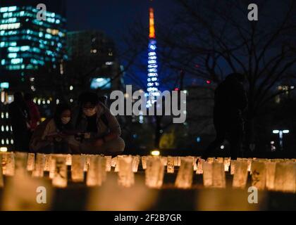 Tokio. März 2021, 11th. Die Menschen sehen Papierlaternen mit Lobreden zum Gedenken an die Opfer des Großen Ostjapanerbebens und Tsunamis in Tokio, Japan am 11. März 2021. Quelle: Christopher Jue/Xinhua/Alamy Live News Stockfoto