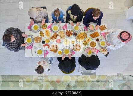 Draufsicht auf muslimische Familie, die während des Ramadan iftar dua zum Fastenbrechen macht. Stockfoto