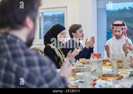 Muslimische Familie macht iftar dua Fasten während Ramadan zu brechen. Stockfoto