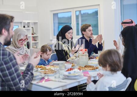Muslimische Familie macht iftar dua Fasten während Ramadan zu brechen. Stockfoto