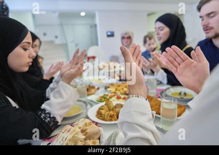 Muslimische Familie macht iftar dua Fasten während Ramadan zu brechen. Stockfoto