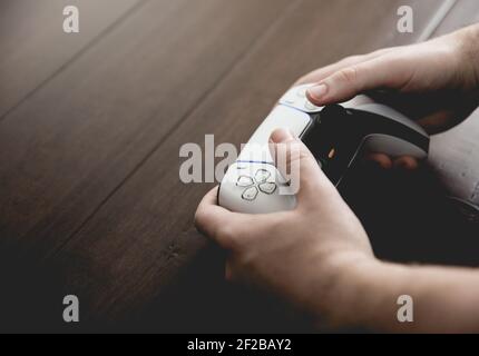 SELBY, GROSSBRITANNIEN, 11. MÄRZ 2021. Nahaufnahme eines männlichen Hands, das ein PlayStation PS5-Controller-Handset mit Kopierplatz verwendet und spielt Stockfoto