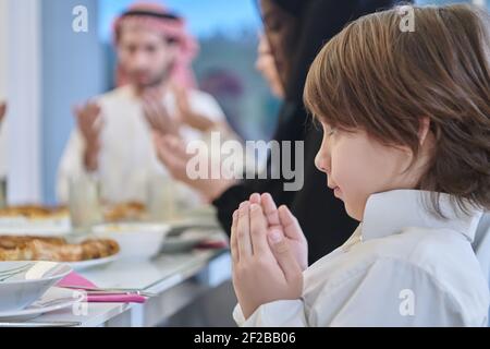 Muslimische Familie macht iftar dua Fasten während Ramadan zu brechen. Stockfoto