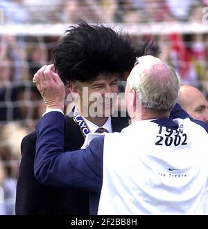 Arsenal V Everton 11/5/02 Bob Wilson setzt Elvis Perücke an Arsene Wenger Bild von Gavin Rodgers 07957 177089 Stockfoto