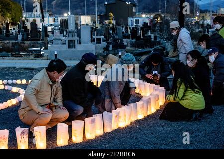 Ishinomaki, Japan. März 2021, 11th. Die Menschen zünden in der Nacht Kerzen an als Symbol des Lichts in der Dunkelheit, um an die vor 10 Jahren Getöteten vor der Tafel "Ganbare Ishinomaki" zu erinnern. Japan ist seit 10 Jahren ein massives Erdbeben, Tsunami und Atomkrise, die den Nordosten Japans hart getroffen haben. Kredit: SOPA Images Limited/Alamy Live Nachrichten Stockfoto