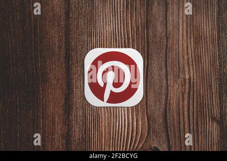 Pinterest rot rundes Logo auf Papier gedruckt mittig platziert auf Holzhintergrund Stockfoto