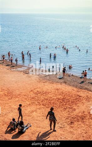 2000 Totes Meer Jordanien Mittlerer Osten - Menschen mit dicken schwarzen Toten Meer Schlamm bedeckt, der vorteilhaft für Hautprobleme ist. Es wird dann durch Baden im Wasser des Toten Meeres abgewaschen. Mövenpick Resort Jordanien die Salzkonzentration des Toten Meeres schwankt um 31,5%. Diese ist ungewöhnlich hoch und daher kann jeder aufgrund des natürlichen Auftriebs leicht im Toten Meer schweben. Das Tote Meer, Salzmeer Buhayrat, Bahret oder Birket ist ein Salzsee, der im Osten von Jordanien und im Westen von Israel und der Westbank begrenzt wird. Es liegt im Jordan Rift Valley, und sein Hauptausfluss ist der Jordan River. Stockfoto