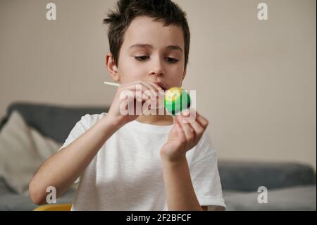 Liebenswert junge Dekoration Osterei mit Pinsel und paints.children's Kreativität Eier malen Stockfoto