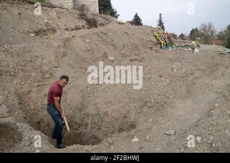 STEPANAKERT, BERG-KARABACH - NOVEMBER 05: Der Totengräber Martin Ghulyan gräbt die Gräber armenischer Soldaten, die am 05. November 2020 in Stepanakert, Berg-Karabach, während des militärischen Konflikts mit aserbaidschanischen Truppen getötet wurden. Die Kämpfe zwischen Armenien und Aserbaidschan um Berg-Karabach in der selbsternannten Republik Arzakh, einem Teil der Republik Aserbaidschan, brachen Ende September in einen sechswöchigen Krieg mit beiden Ländern auf, die sich gegenseitig der Provokation beschuldigten, die Tausende Tote hinterließ. Stockfoto