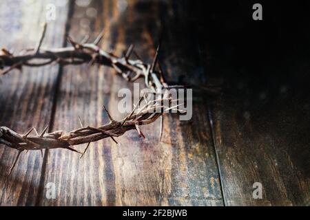 Christliche Dornenkrone wie Christus trug mit Bluttropfen über einem rustikalen Holzhintergrund oder Tisch. Selektiver Fokus mit unscharfem Hintergrund. Stockfoto