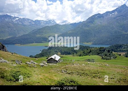 Berghütte mit Bergsee im Hintergrund, mit Panoramablick auf das Engadiner Tal, in der Schweiz. Stockfoto