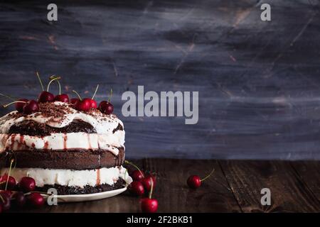 Köstliche Schwarzwälder Kirschkuchen, Schwarzwald Pie Dessert, über einem dunklen rustikalen Holztisch. Selektiver Fokus mit unscharfem Hintergrund und freiem Platz für Stockfoto