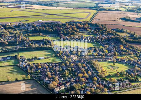 Eine Luftaufnahme des Cotswold-Dorfes Upper Rissington, Gloucestershire, UK - Little Rissington Airfield ist im Hintergrund zu sehen. Stockfoto